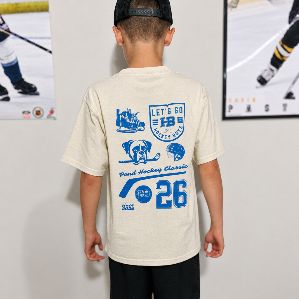 Youth model wearing the Light Sand Youth Hockey T-Shirt, back view, with hockey posters in the background